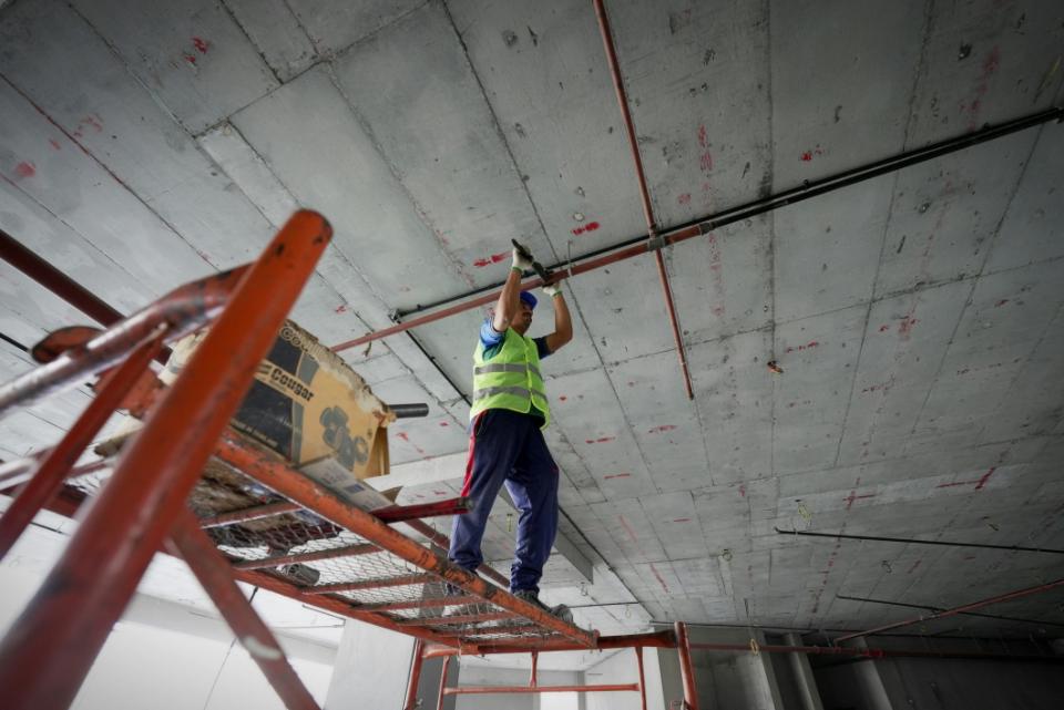 Trabajador en andamio instalando tuberías